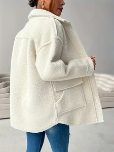 Close-up of beige sherpa jacket showing plush texture, lapel collar, and large pockets