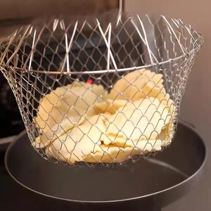 Folding stainless steel chef basket lifting dumplings from a pot in a kitchen setting