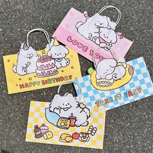 Flat lay of four cute cartoon puppy gift bags with handles on a textured grey surface