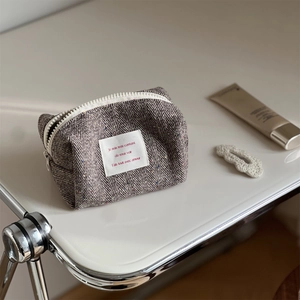 Herringbone tweed cosmetic bag with colorful dots and vintage fabric label