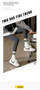Detail of white crew socks with double black stripes paired with grey leggings