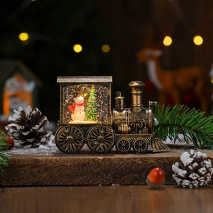 Close-up of a bronze Christmas train lantern with snowman scene and bokeh lighting