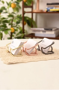 Three-piece set of minimalist metal business card holders in gold, rose gold and black
