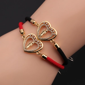 Close-up of woven adjustable heart bracelets with gold plating and zircon charms
