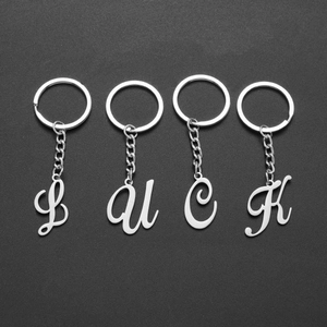 Polished stainless steel letter L U C K charms keychain set on grey background
