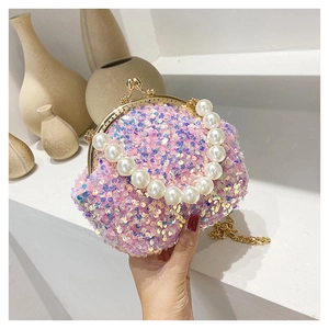 Detailed close-up of pink sequin evening bag with pearl handle and golden metal chain