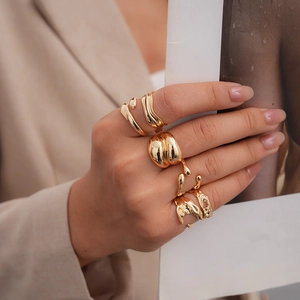 Dettaglio di anelli fluidi placcati in oro 18K indossati con stile su mano elegante