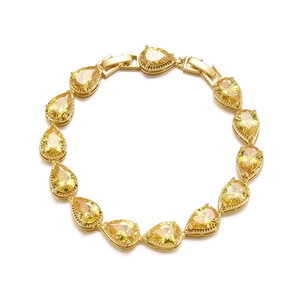 Macro shot of 13 pear-cut yellow cubic zirconia stones on a gold-plated link bracelet