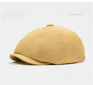 Detailed view of light yellow newsboy cap showing twill fabric texture and top button