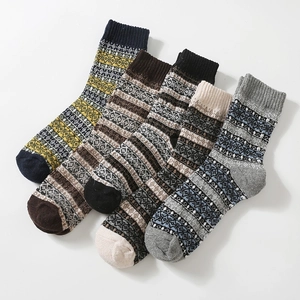 Close-up of five pairs of thick wool socks with Nordic patterns and ribbed cuffs