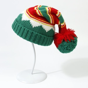 Detailed knit texture of a colorful Christmas beanie with pompom on a display stand