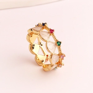 Detail of gold-plated geometric ring featuring white enamel and colorful cubic zirconia