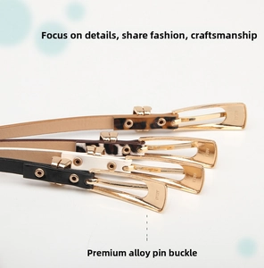 Detail of four thin fashion belts in black white leopard and brown with alloy buckles