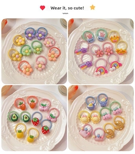 Detail view of colorful fruit and floral resin charms on soft elastic hair ties for girls