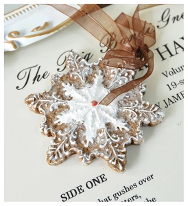 Macro detail of snowflake resin ornament with white relief patterns and glitter accents