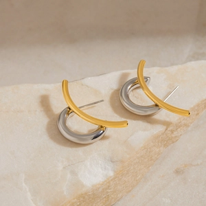 Macro shot of two-tone geometric metal earrings in polished gold and silver finish