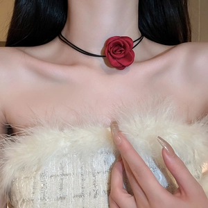 Detail view of a handmade red fabric rose choker with black double-layer velvet cords