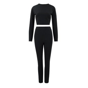 Vue détaillée de l'ensemble deux pièces noir avec haut court à manches longues et pantalon ajusté