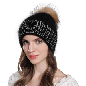 Women's black knit winter beanie with tan raccoon fur pom and silver dot pattern