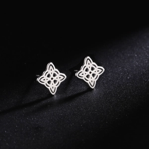 Macro detail of silver witch knot earrings in polished stainless steel on black background