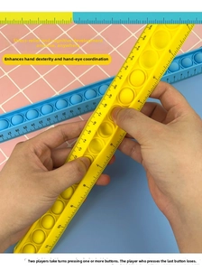 Detail showing hand holding a flexible 28cm silicone pop-it ruler toy in yellow and blue