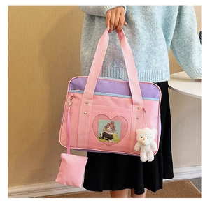 Pink and purple JK uniform ita bag featuring heart window and plush bear charm detail