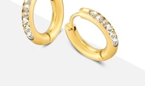 Macro shot of gold hoop earrings with micro-pave cubic zirconia on gray background
