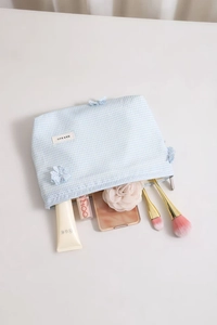 Close-up of blue plaid toiletry bag with 3D flower decoration and inner storage