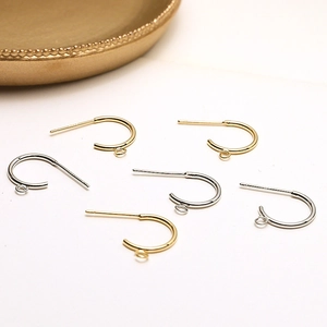 Close-up of C-shaped 18k gold and silver plated earring hooks with loop for DIY jewelry