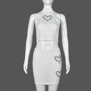 Detail des weißen Rippstrick-Zweiteilers mit Strass-Herz-Ausschnitten an Crop-Top und Rock