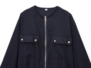 Detail of navy linen-blend jacket featuring silver zipper and gold metallic pocket buttons