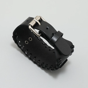 Close-up of black braided leather Viking bracelet with metallic clasp and compass detail