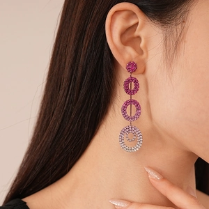 Macro shot of long drop earrings with purple gradient crystals on a female model