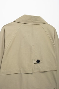 Close-up of the khaki short jacket's back detail with decorative button flap and stitching