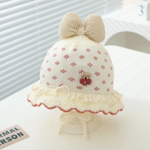 Detailansicht der Baby-Strickmütze mit Cord-Schleife, Kirschdekor und Spitze