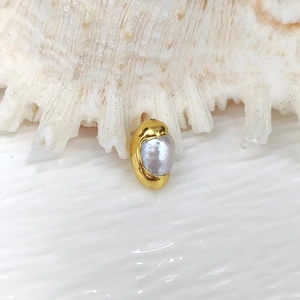 Macro detail of natural grey pearl encased in a gold plated metal frame for DIY jewelry