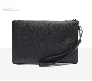 Macro shot of black lychee grain leather wristlet bag with detachable strap and metal zip