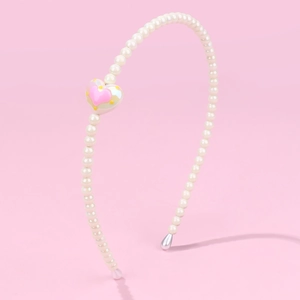 Close-up of a handmade pearl headband featuring a pink and yellow heart charm on pink