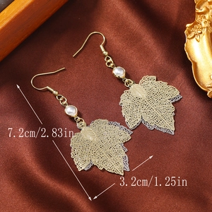 Detail view of gold hollow leaf earrings with white pearls and size measurements