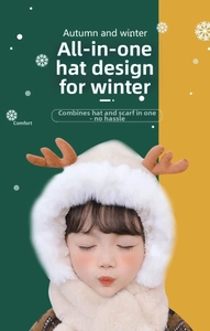 Detail of deer antlers and white faux fur trim on a beige knitted kids winter hood hat