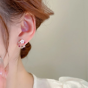 Primo piano di modella con orecchini a lobo a fiore con perle, cristalli rosa e strass