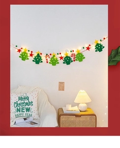 Close-up of felt Christmas light string with trees, stars and candy canes on wall