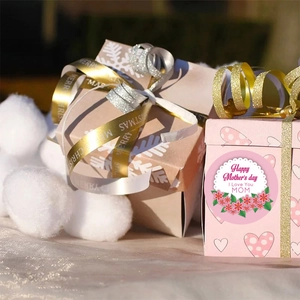 Muttertagsaufkleber auf rosa Geschenkboxen mit festlichen Bändern und Dekoration