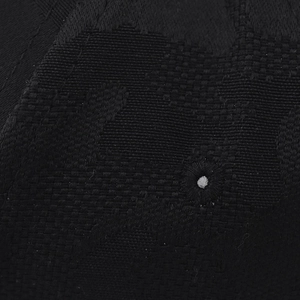 Macro shot of high-density black camouflage jacquard fabric showing fiber texture details