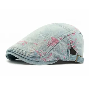 Light blue denim ivy cap with pink graffiti spray paint art and adjustable metal buckle