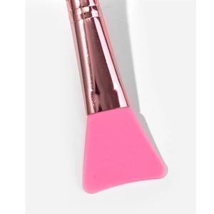 Close-up of pink silicone mask brush head with rose gold metal ferrule on white background