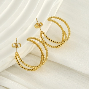 Boucles d'oreilles minimalistes dorées 18 carats double épaisseur en C sur plateau blanc