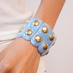 Macro shot of light blue marble acrylic cuff bracelet with gold domed metal studs