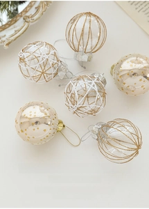 Detailed view of 6cm transparent Christmas balls with gold grid and star patterns