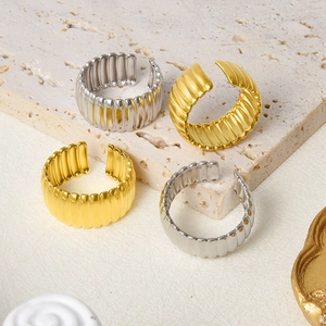 Detailed view of the ribbed texture and metallic luster on gold and silver open rings